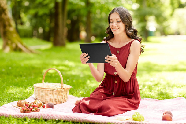 happy woman with tablet computer on picnic at park - Zdjęcie, obraz