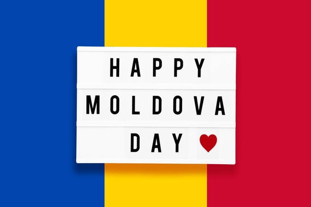 FELIZ DÍA DE MOLDOVA escrito en una caja de luz sobre un fondo de color de la bandera de Ucrania. Concepto del día de la independencia. - Foto, imagen