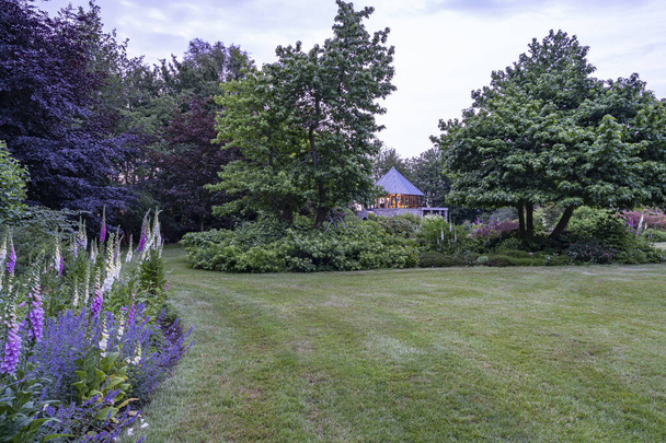 During twilight a sea of tranquility arises in this beautifully landscaped garden - Foto, Bild