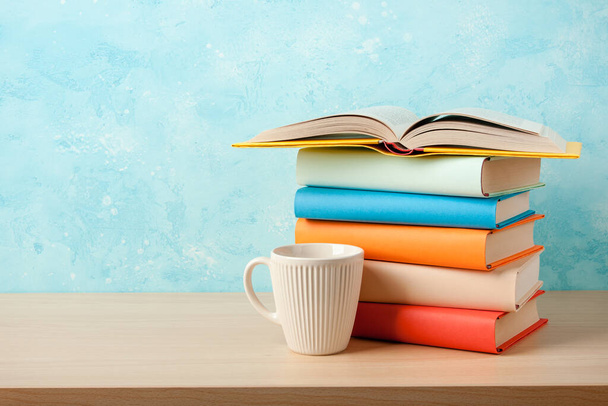 Stack of books and mug on wooden table - Fotó, kép