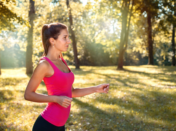 Portrait of young sporty woman running in the park outdoor. Healthy lifestyle concept - Foto, Imagen