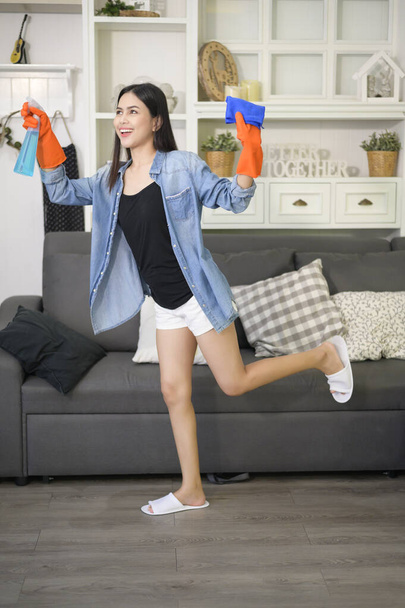 A woman with cleaning gloves using alcohol spray sanitiser to cleaning house, healthy and medical, covid-19 protection at home concept . - Φωτογραφία, εικόνα