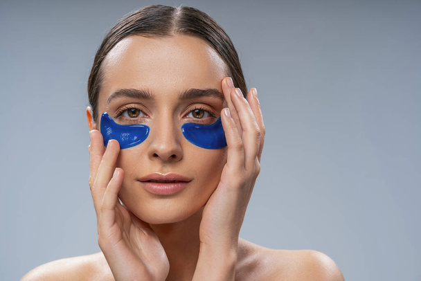 Tranquil young woman with under-eye gel pads - Photo, Image