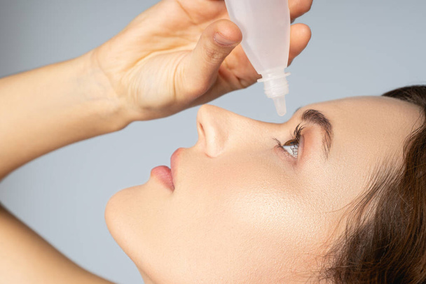 Female applying a liquid medication for eyes - Fotó, kép