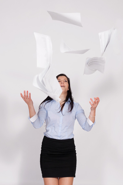 Woman throws out paper into the air - Foto, afbeelding