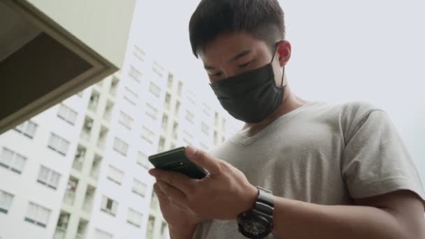 Młody człowiek korzystający z telefonu komórkowego w mieście - Materiał filmowy, wideo