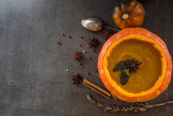 Butternut squash soup in pumpkin bowl. Top view photo of fresh vegetables on a table. Autumn receipts.  - Photo, Image