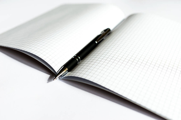 Felülnézet Kockás notebook fekete tollal, fehér háttérrel. A szöveg helye.Másolási hely.Banner hirdetés. - Fotó, kép