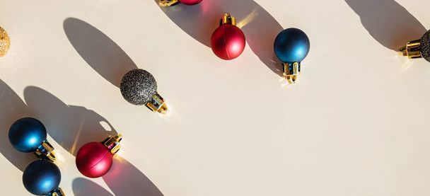 Christmas decor. Colorful baubles on white background with hard shadows. Flat lay, top view. New year concept. - Fotó, kép