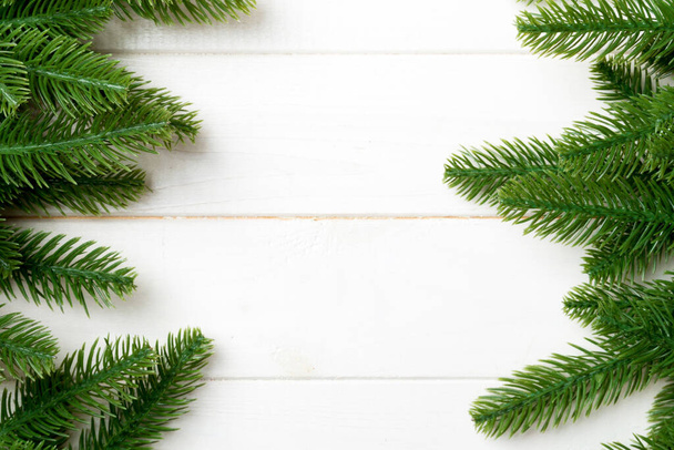 Top view of Christmas background made of fir tree branches. New year concept with copy space on wooden background. - Foto, Bild