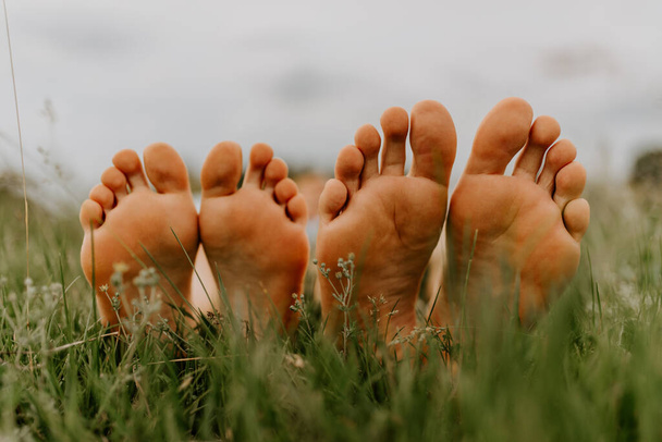 les pieds d'un homme et d'une femme. pieds d'un homme et d'une fille sur l'herbe. Pique-nique familial en été dans le parc sur herbe verte non tondue. - Photo, image