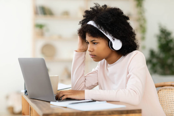 Black Teenager Girl At Laptop Studying Online Sitting At Home - Foto, afbeelding