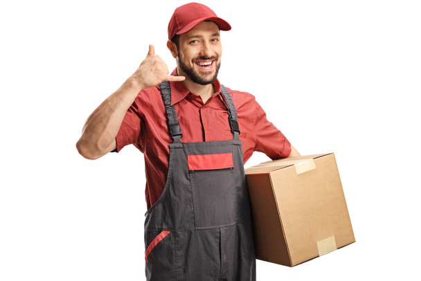 Worker holding cardboard boxes and gesturing a phone call with hand isolated on white background - Photo, image