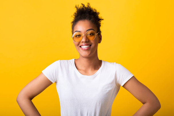 sourire noir adolescent regarder caméra dans lunettes de soleil - Photo, image
