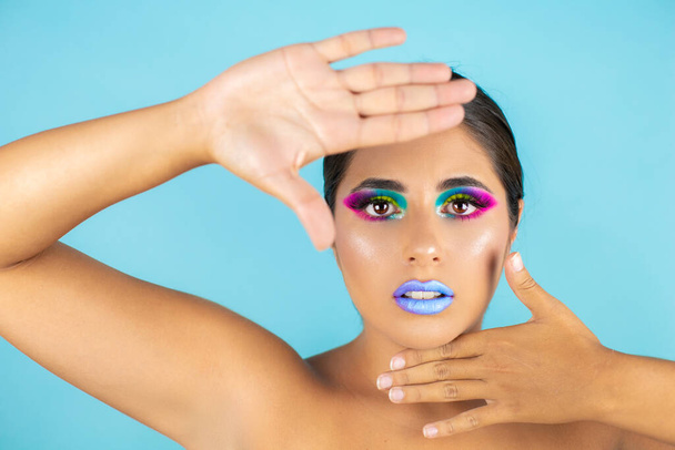 Beauty portrait of female model with vivid makeup on blue background and blue lips. - Φωτογραφία, εικόνα