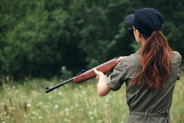 Donna all'aperto Tenere un'arma è uno stile di vita di caccia berretto nero  - Foto, immagini