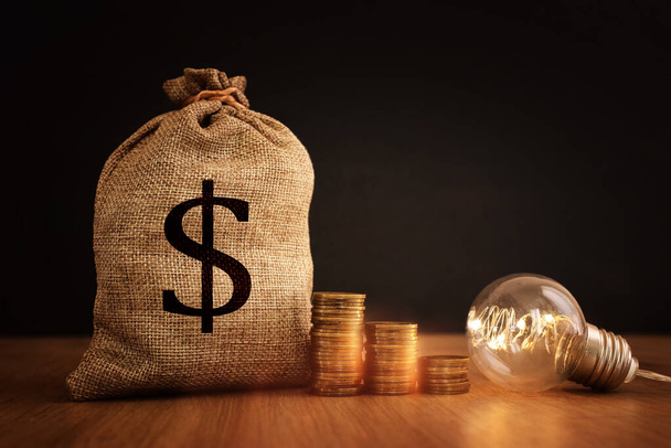 Concept image of lightbulb with coins stack. Innovate and money saving idea - Φωτογραφία, εικόνα