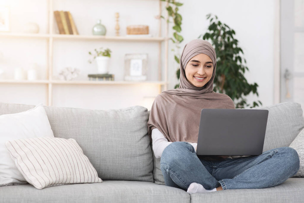 現代のフリーランスのコンセプト。若いアラビア人の女性が自宅でノートパソコンで働いている - 写真・画像