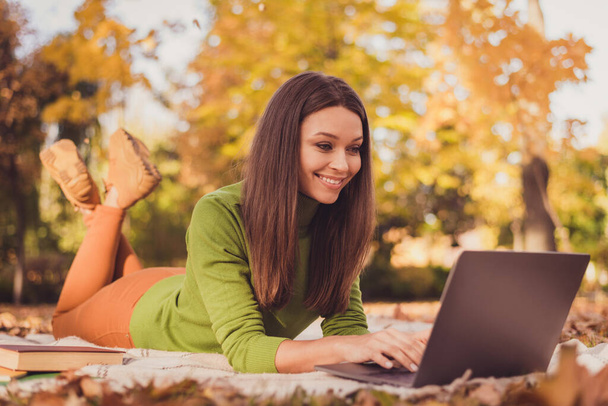 Photo of pretty charming smart lady come autumn park leaves ground lay blanket smiling work computer freelance project receive payment message from client wear green turtleneck outdoors - Φωτογραφία, εικόνα