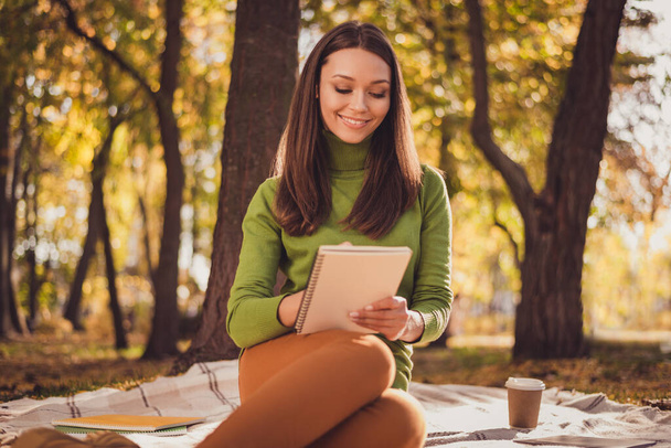Photo of pretty lovely dreamy lady sit blanket drink coffee smiling preparation exams quiet place autumn park friends carefree day wear green turtleneck orange pants outdoors - Photo, Image