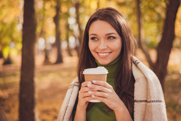 Photo of charming lovely dreamy lady stay hold cup drink coffee beaming smiling wrapped coverlet autumn park friends carefree day wear green turtleneck orange pants outdoors - Фото, изображение