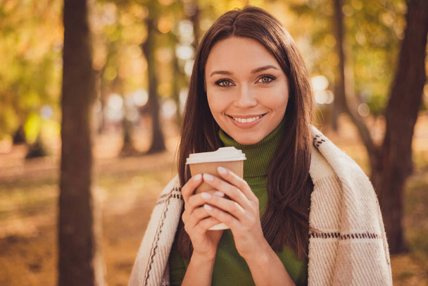 Photo of cute lovely lady stay hold cup drink coffee beaming smiling wrapped plaid blanket comforting cold chill weather spend free time wear green turtleneck orange pants outdoors - Fotoğraf, Görsel