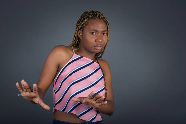 Beautiful young african american woman showing stop gesture with both hands while standing on gray background  - Foto, afbeelding
