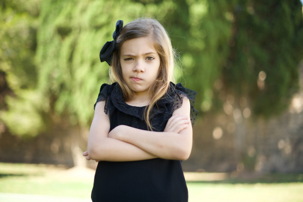 Immagine di arrabbiato giovane ragazza caucasica carina in abito nero braccia incrociate in piedi  - Foto, immagini