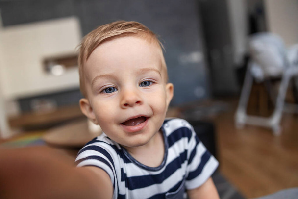 Closeup of cute blond toddler reaching for the camera. - Foto, Imagem