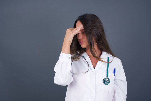 Very upset, charming doctor woman touching nose between closed eyes, wants to cry, having stressful relationship, worry about conflict with her lover, having troubles with work - Фото, зображення