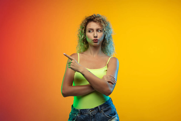 Caucasian young womans portrait on gradient studio background in neon - Фото, зображення
