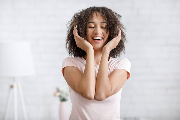 Retrato de mujer afroamericana feliz en auriculares, disfrutando de la música - Foto, imagen