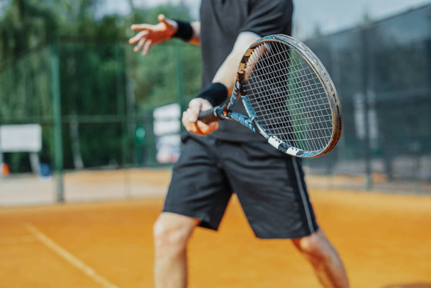 Close Up of Man Playing Tennis At Court And Beating The Ball With a Racket. Player is Hitting Ball With Racket While Playing Match - Foto, immagini