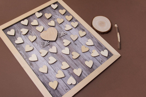 Primer plano del marco de madera con un par de corazones de madera, Mrs y Mr y pluma. - Foto, Imagen