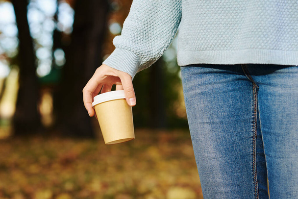 woman hold cup of coffe takeaway in autumn park - Zdjęcie, obraz