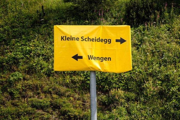 Простий жовтий знак для Венґена і Кляйне Шайдеґґ у Бернських Альпах (регіон Юнґфрау, Швейцарія). - Фото, зображення