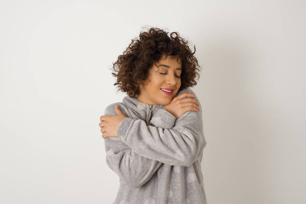Fiatal gyönyörű nő pizsamában pózol a stúdióban  - Fotó, kép