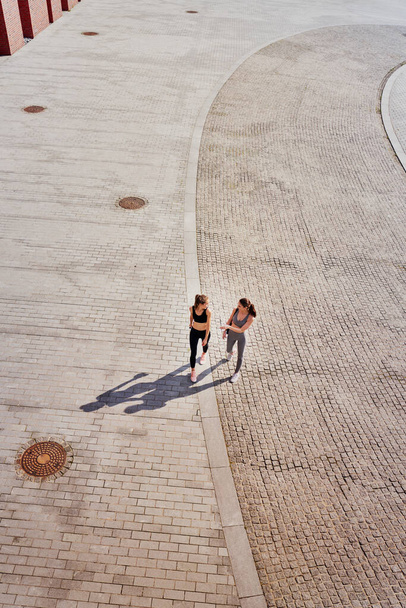 Top näkymä kaksi urheilullista naista menossa koulutukseen                                - Valokuva, kuva