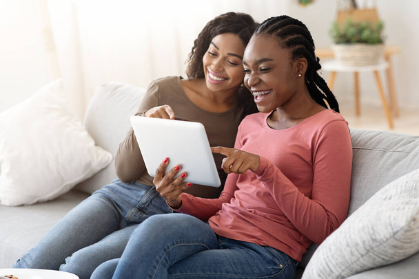 African young women using digital tablet together - Фото, изображение