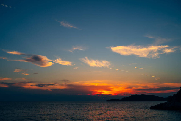 Fiery red sunset sky over the sea. - 写真・画像