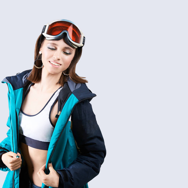 Κορίτσι των σπορ ομορφιάς. Σακάκι snowboard. Όμορφη νεαρή γυναίκα με ρούχα γυμναστικής. - Φωτογραφία, εικόνα