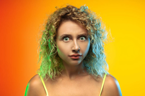 Caucasian young womans portrait on gradient studio background in neon - Foto, imagen