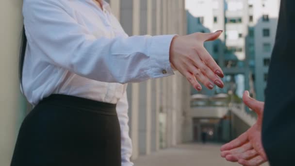 Οι επιχειρηματίες κάνουν χειραψία. Επιχειρηματίας σφίγγει το χέρι με μια γυναίκα συνάδελφο σε εξωτερικούς χώρους σχετικά με τα κτίρια γραφείων επιχειρήσεων φόντο - Πλάνα, βίντεο