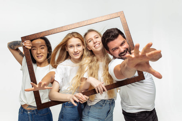 Group of adorable multiethnic friends having fun isolated over white studio background - Zdjęcie, obraz