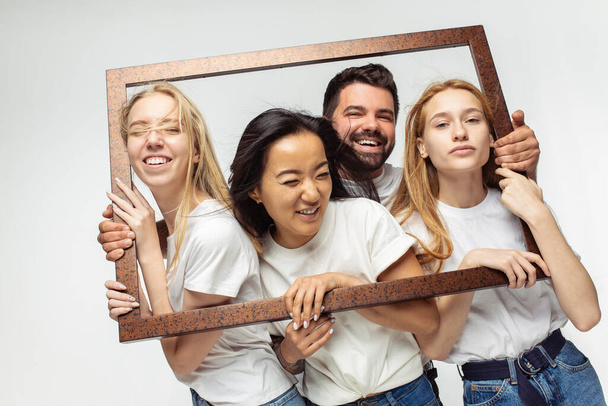 Group of adorable multiethnic friends having fun isolated over white studio background - Valokuva, kuva