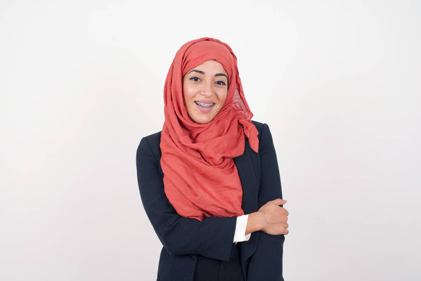 Ihana kaunis musliminainen pukeutuu mustaan bleiseriin ja hijabiin, jolla on viehättävä hymy ja ystävällinen ilme ja joka haluaa osoittaa rakkautensa ja myötätuntonsa. Sydämeni on sinua varten.! - Valokuva, kuva