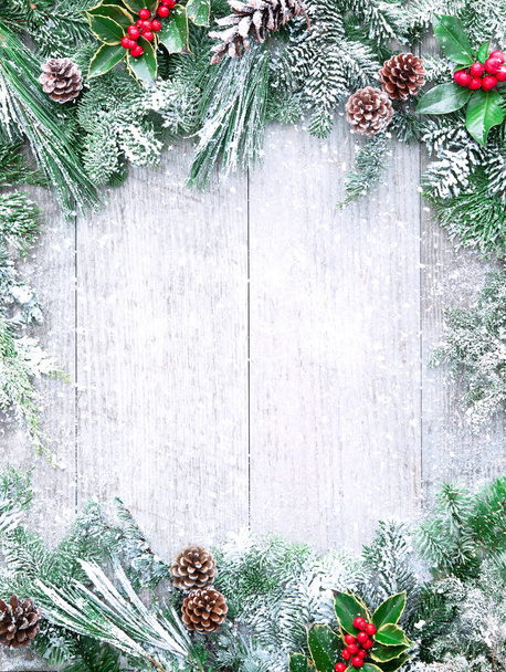 Christmas and New Year background with fir branches, holly and snowfall on wooden white board - Foto, Imagem