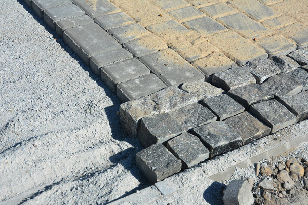 Een close-up van granieten kasseistrook op een rotsstof of crusher run sub-base. - Foto, afbeelding
