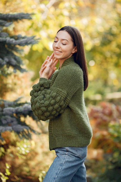Girl in a kniten sweater standing on trees background - Foto, Imagem