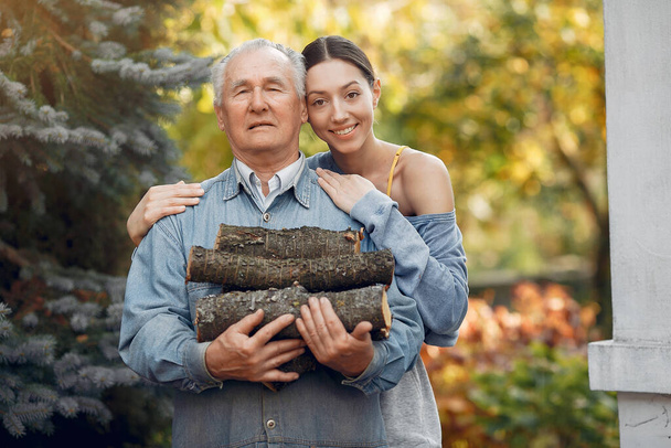 薪を手に庭に孫娘と祖父 - 写真・画像
